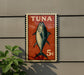 a sign with a fish illustration and the word "Tuna" written on it, mounted on a wall.