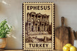 A framed illustration of the Library of Ephesus, a famous ancient Greek Library located in Turkey, is displayed on a wall.