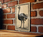 a large, detailed illustration of an ostrich on a wooden surface against a brick wall background.