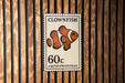 A metal sign with a clownfish illustration and the text "CLOWFISH" and "60c AMPHIPRIONINAE" printed on it.