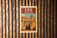 A vintage-style poster of the Fes Market in Morocco, featuring an illustration of the market's iconic archway and buildings.