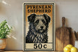 A vintage-style sign for a Pyrenean Shepherd, featuring a black and white illustration of the dog's face, is displayed on a shelf next to a wooden cutting board and some lemons.