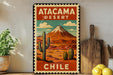 A vintage-style metal sign depicting the Atacama Desert in Chile, with a mountain and desert landscape, along with a cactus and other desert elements.