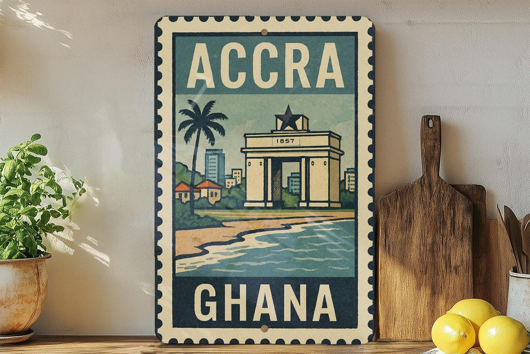 a vintage-style metal sign with the text "ACCRA GHANA" and an illustration of a building, palm tree, and beach. The sign is displayed on a shelf next to a wooden cutting board and a potted plant.