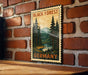 A vintage-style metal stamp depicting a forest scene with pine trees and a river, mounted on a brick wall.