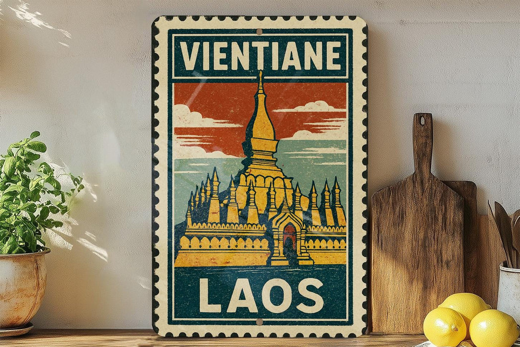 A vintage-style metal sign with a temple illustration and the text "Vientiane Laos" is displayed on a shelf, accompanied by a potted plant, a wooden cutting board, and some lemons.