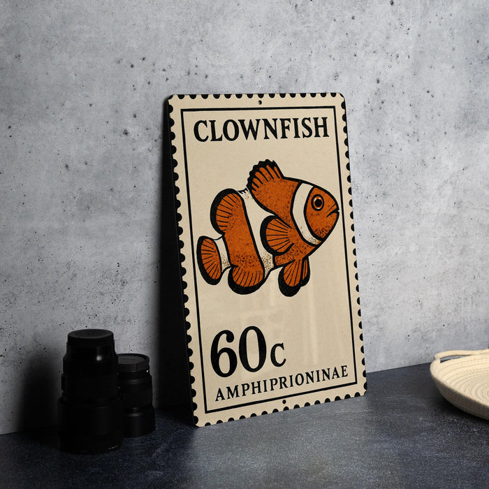 A metal stamp featuring an illustration of a clownfish, with the text "CLOWNFISH" and "AMPHIPRIIONAE" printed on it.