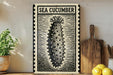 a framed illustration of a sea cucumber on a wooden shelf, accompanied by a wooden cutting board and a potted plant.