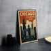 A vintage-style metal sign with the text "CHICAGO ILLINOIS USA" and an illustration of a city skyline, placed on a gray countertop next to some black camera lenses.