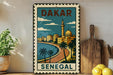 A vintage-style metal stamp with a colorful illustration of Dakar, Senegal, featuring a cityscape, palm trees, and a mosque.