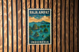 A vintage postage stamp from Indonesia featuring a tropical island landscape with palm trees and water.