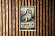 A sign featuring a seal is mounted on a wooden wall.