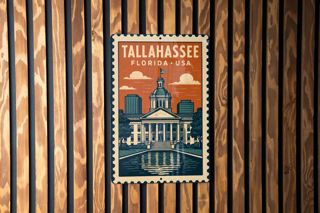 A metal sign with a vintage-style illustration of Tallahassee, Florida, USA, mounted on a wooden wall.