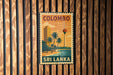 A vintage-style metal sign with the text "COLOMBO" and "SRI LANKA" is displayed on a wooden wall.