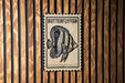A metal sign with a butterfly fish illustration is mounted on a wooden wall.
