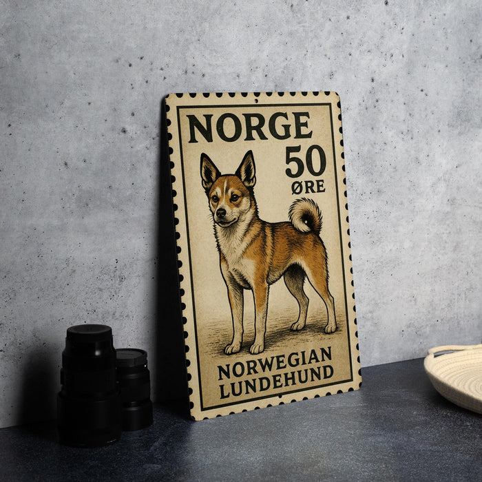 A Norwegian Lundehund dog is depicted on a Norwegian postage stamp, which is placed on a table next to some black camera lenses.