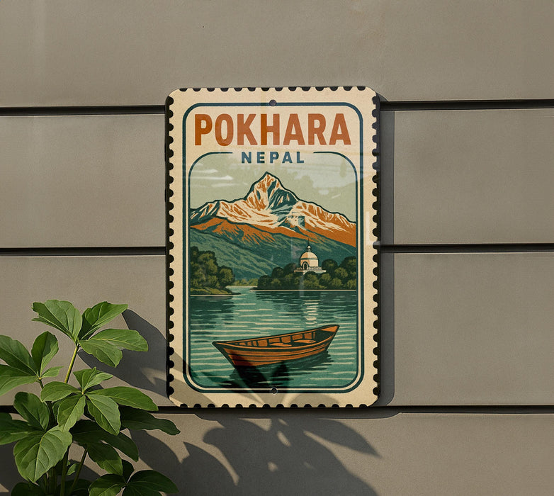 A vintage-style sign for Pokhara, Nepal, featuring a mountain landscape with a boat on the water.
