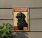 A sign featuring a black flat-coated retriever dog, with the text "FLAT-COATED RETRIEVER" and a price of "20c" displayed on it.