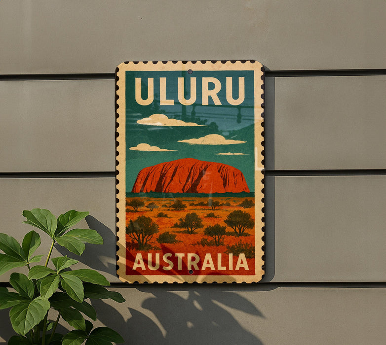 A vintage-style sign with the text "ULURU AUSTRALIA" and an illustration of Uluru, a large red rock formation in the Australian outback, is displayed on a wall.