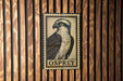 a metal sign with an illustration of an Osprey, a bird of prey, mounted on a wooden wall.