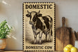 a decorative sign with a cow illustration, placed on a shelf next to a wooden cutting board and some lemons.