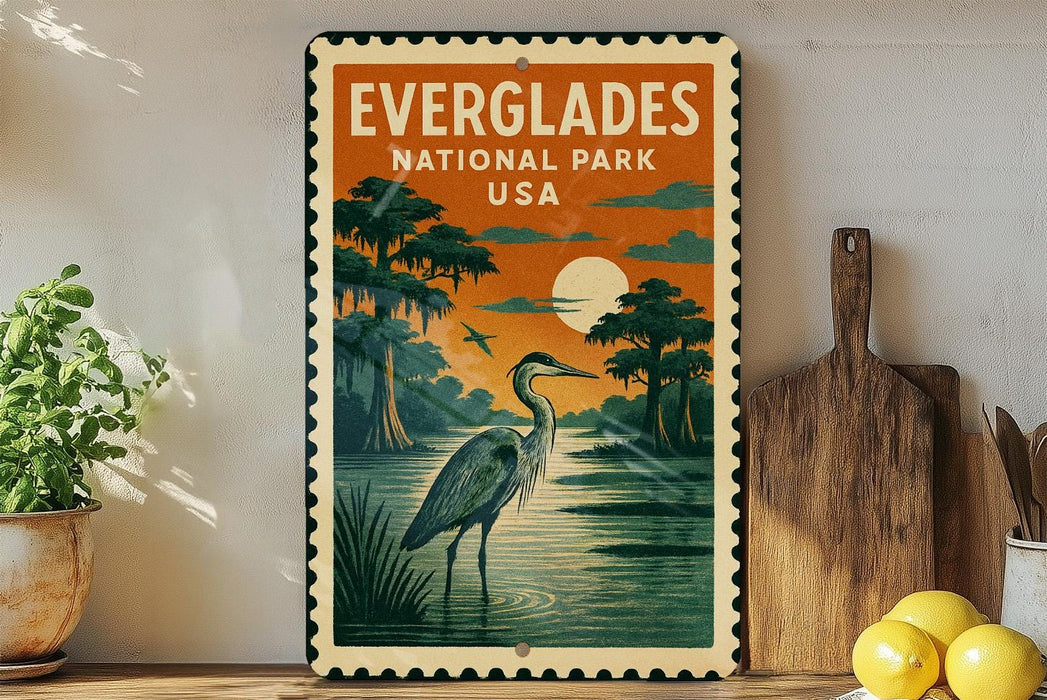 a vintage-style metal sign with a postage stamp design, depicting a serene scene of a bird standing in a body of water with a sunset in the background.