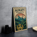 A metal sign with a mountain landscape and a building, likely representing the Almaty region in Kazakhstan, is displayed on a table.