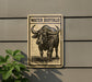 a sign with a picture of a buffalo, mounted on a wall.