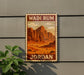 A vintage-style metal sign with the text "Wadi Rum Jordan" displayed on it, featuring an illustration of a desert landscape with mountains in the background.