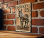 a wooden table with a framed illustration of a donkey on it, mounted on a brick wall.