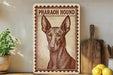 a wooden sign with a drawing of a dog, specifically a pharaoh hound, on it. The sign is placed on a shelf next to a potted plant and a wooden cutting board.