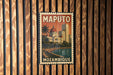 A vintage-style poster of Maputo, Mozambique, is displayed on a wooden wall.