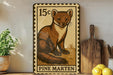 A 15c postage stamp featuring a pine marten, a type of small mammal, is displayed on a shelf next to a wooden cutting board and some lemons.