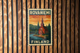 A vintage-style postage stamp from Finland featuring a church and a landscape with trees and a river.