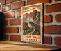 A sign depicting the Great Wall of China is hanging on a brick wall.