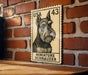 A miniature schnauzer dog is depicted on a US postage stamp, which is mounted on a brick wall.