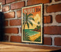 A vintage postage stamp featuring a tropical beach scene with palm trees and a sunset over the ocean.
