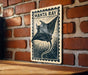 A framed image of a manta ray, a type of ray, is displayed on a brick wall.