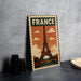A vintage-style metal sign featuring the Eiffel Tower, a famous landmark in France, is displayed on a table.