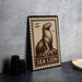 A framed illustration of a sea lion is displayed on a wall, with a stack of black camera lenses to the left and a white plate to the right.