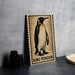 A framed illustration of a penguin is displayed on a wall, with a stack of black camera lenses to the left and a woven basket to the right.