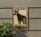 a sign with a picture of a giraffe, mounted on a wall.
