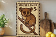 a wooden shelf with a framed illustration of a brown lemur, a type of primate, on a branch. The lemur is depicted in a playful and curious manner, sitting on the branch and looking up. The shelf also has a potted plant, a wooden cutting board, and some lemons.