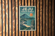 A poster of Jeju, South Korea, featuring a mountain landscape with a temple and a sun in the sky.