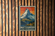 A vintage-style metal sign with a mountain landscape and the text "MATTERHORN SWITZERLAND" is displayed on a wooden wall.