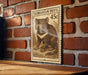 A wooden table with a framed image of a Tasmanian Devil, a marsupial native to Australia, mounted on a brick wall.