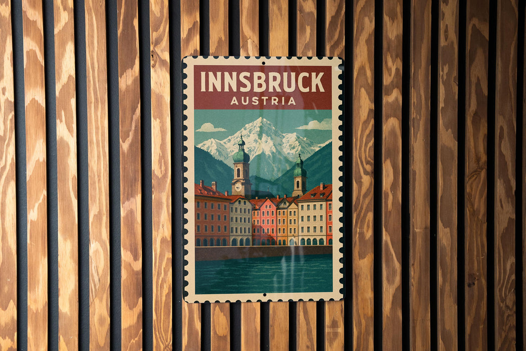 A vintage-style poster of Innsbruck, Austria, featuring a mountain landscape and colorful buildings, is displayed on a wooden wall.