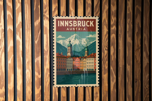 A vintage-style poster of Innsbruck, Austria, featuring a mountain landscape and colorful buildings, is displayed on a wooden wall.
