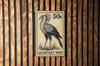 A 50 cent postage stamp featuring a black and white illustration of a bird, which appears to be a Secretary Bird.