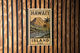 A vintage-style metal sign with the text "HAWAII ISLAND USA" and an illustration of a tropical landscape with palm trees and a mountain.